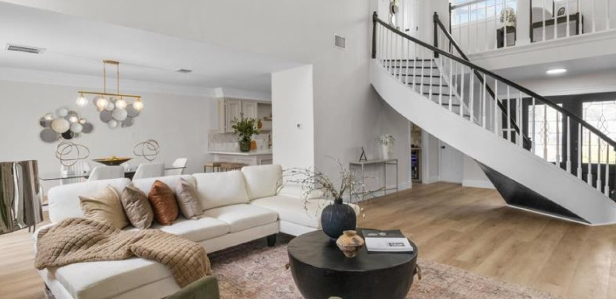 Bright staged living room with a staircase