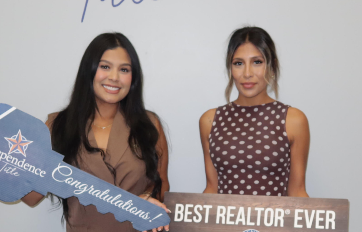Angie Aguilar and a client holding a key at Independence Title