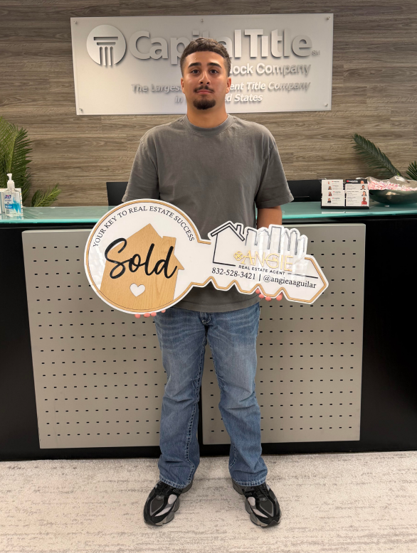 Client holding a Sold key at Capital Title