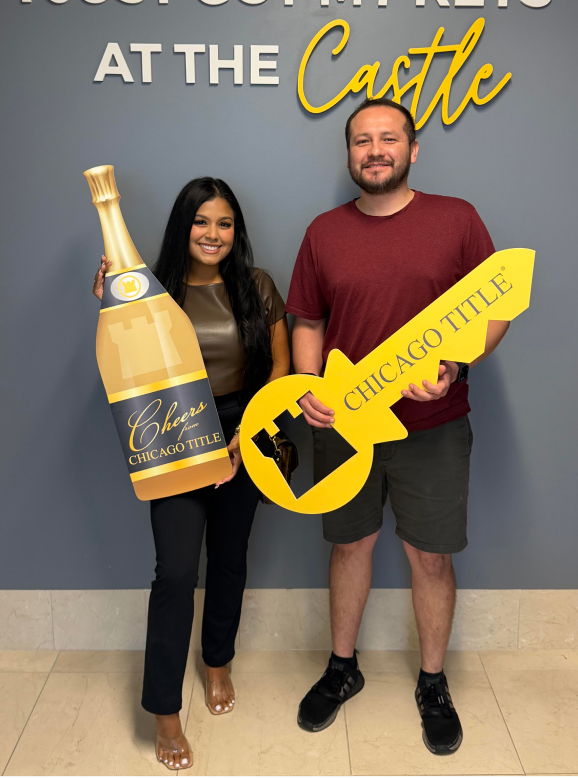 Clients with a Sold champagne bottle and key at Chicago Title