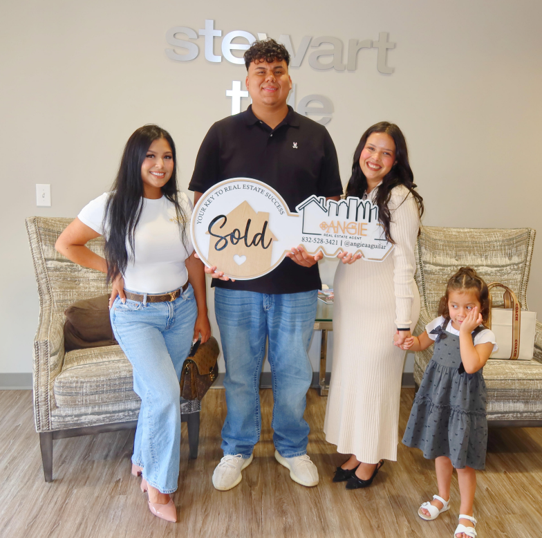 Family holding a Sold key at Stewart Title