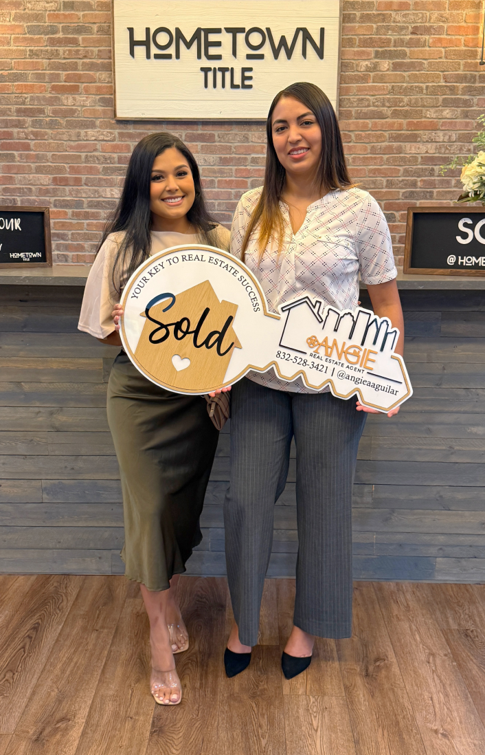 Two clients holding a Sold key at Hometown Title