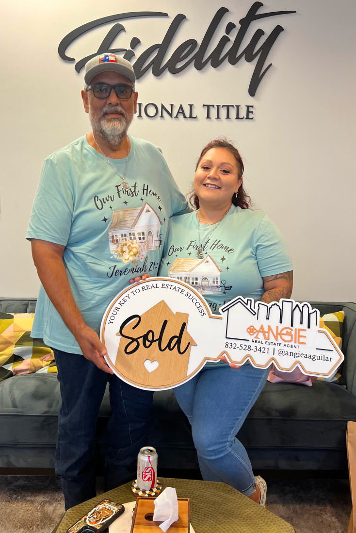 Couple holding a Sold key at Fidelity National Title