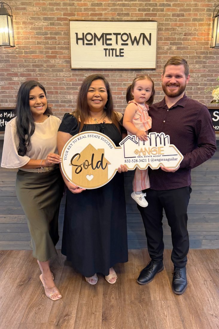 Family holding a Sold key at Hometown Title