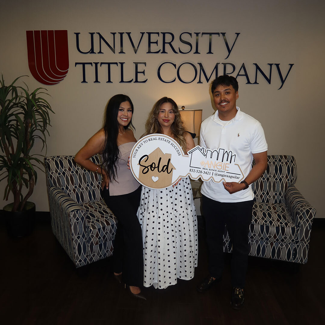 Angie Aguilar with clients holding a Sold key at University Title Company