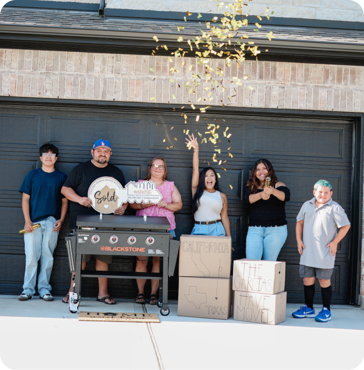 Family celebrating their new home with a Sold sign in front of a garage